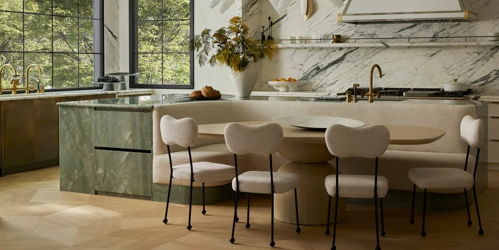 Designer kitchen with marble island and gold pendant lights in a bright space