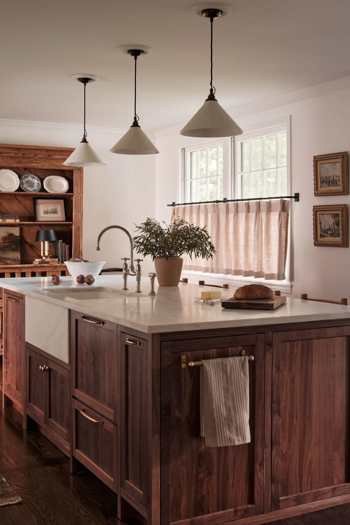 Kitchen with peach-toned cabinets, marble counters, and gold faucet