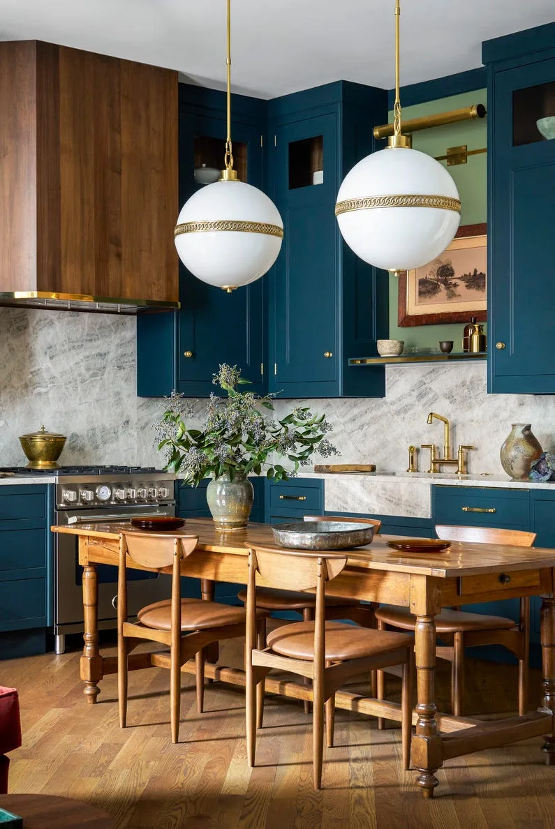 Modern kitchen with blue cabinetry, white island, and pendant lights
