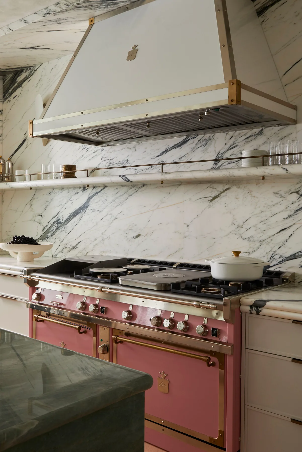 Vintage pink stove with chrome trim and four burners against tiled backsplash